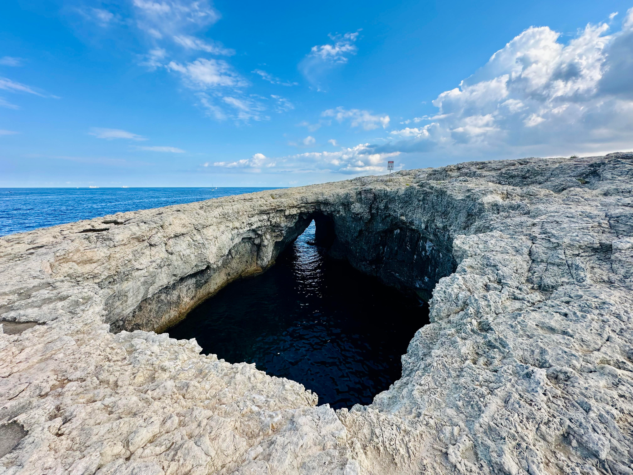 Aerial view of Coral Lagoon in Mellieħa, Malta — natural sea cave with crystal clear turquoise water.