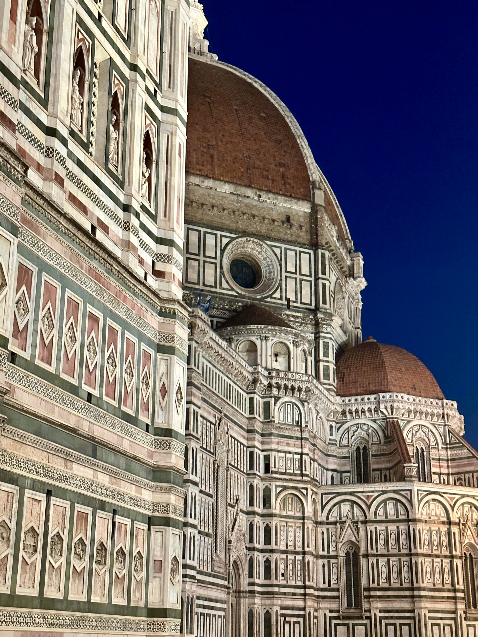 Florence Duomo (Cathedral of Santa Maria del Fiore) with its iconic red-tiled dome and intricate Renaissance facade in the city center of Florence, Italy.