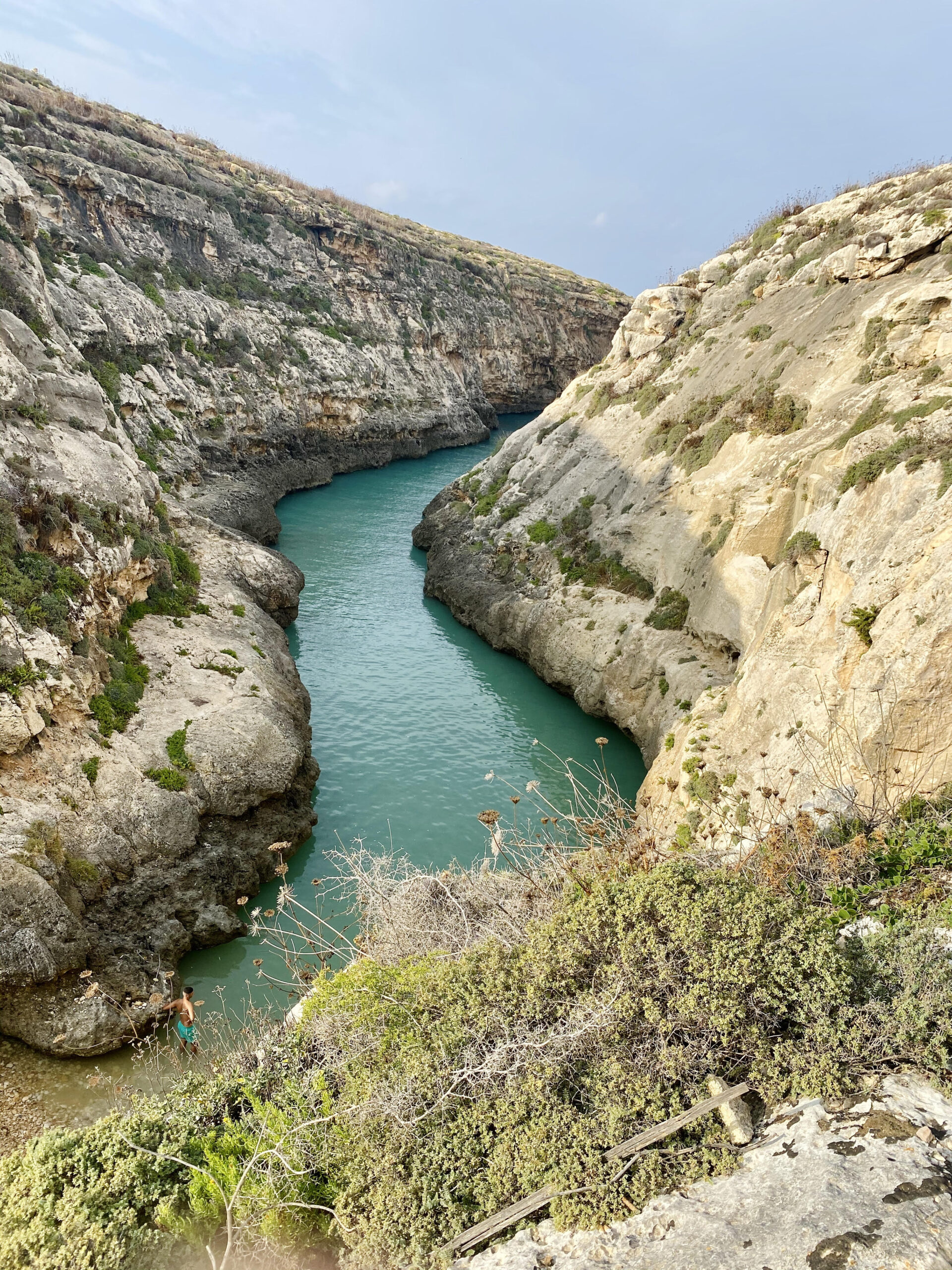 Wied il-Għasri narrow valley in Gozo leading to a small rocky beach and clear blue water